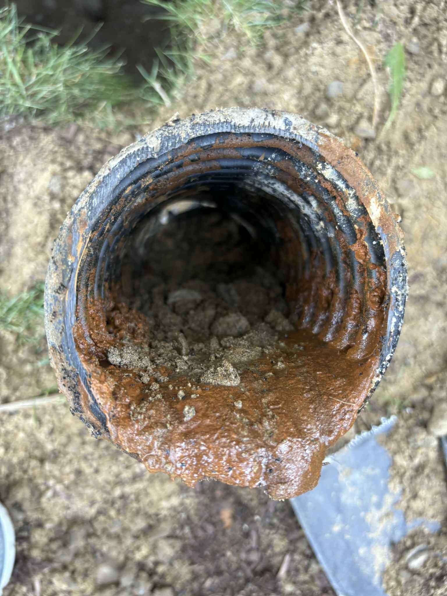 Drain de fondation endommagé par la rouille et les dépôts de terre à Saint-Jérôme